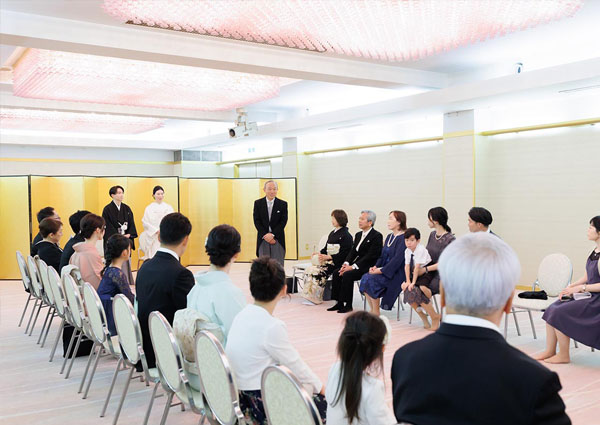 金屏風の前で行われる親族紹介の儀。新郎新婦と円座になった親族一同。