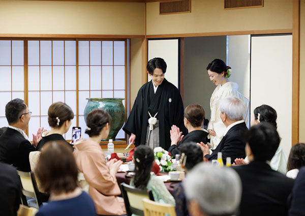 ゲストの拍手に送られ、笑顔で会場を後にする紋付袴の新郎と白無垢の花嫁。