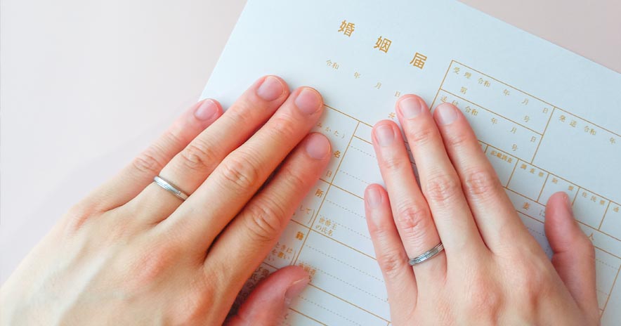 披露宴会場で紋付袴の新郎と白無垢の新婦が鏡開きを行う様子。周囲ではゲストがスマートフォンでその瞬間を撮影している