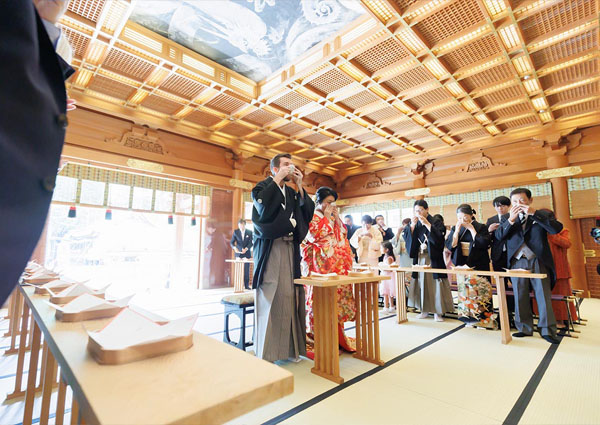 総檜造りの社殿内で行われる神前式と見守る参列者