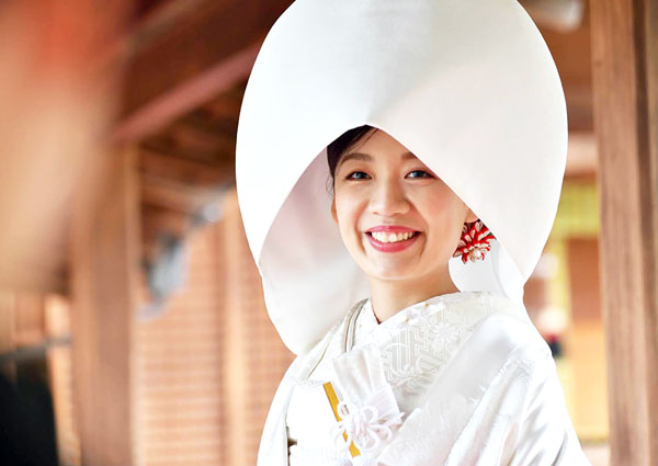 綿帽子をかぶり微笑む白無垢姿の花嫁