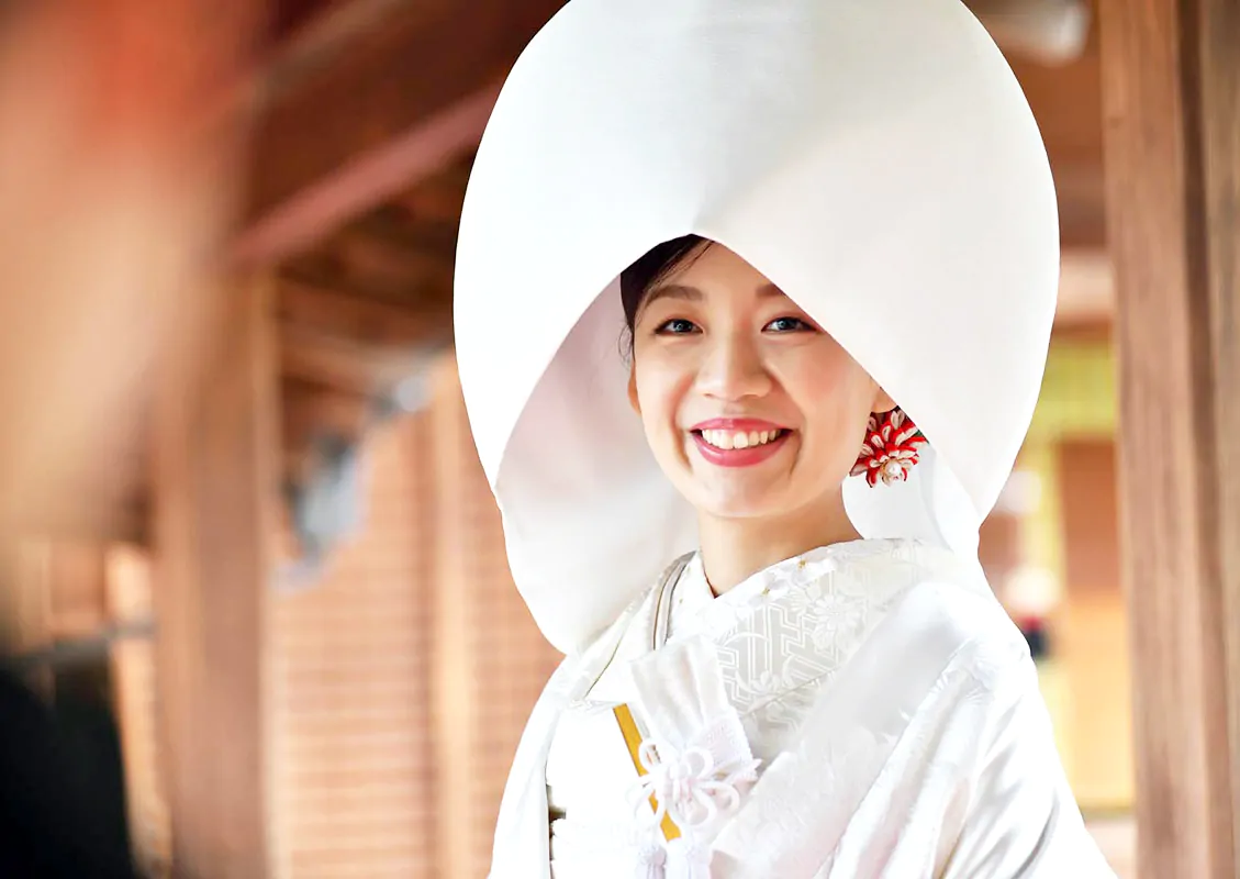 綿帽子をかぶり微笑む白無垢姿の花嫁