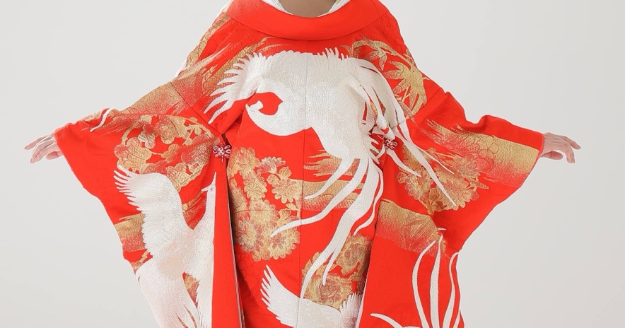 両袖を広げた赤い色打掛の背中一面に、白い鳳凰と金色の草花の刺繍が広がる後ろ姿