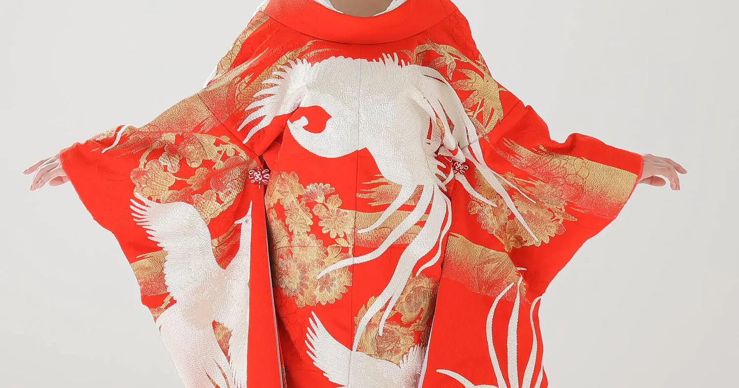 両袖を広げた赤い色打掛の背中一面に、白い鳳凰と金色の草花の刺繍が広がる後ろ姿